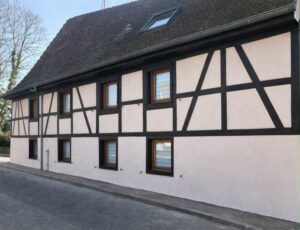 Longue façade à colombages rénovée d'une maison alsacienne avec lucarnes