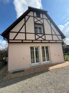Pignon à colombages rénové d'une maison alsacienne, enduit clair et bois foncé